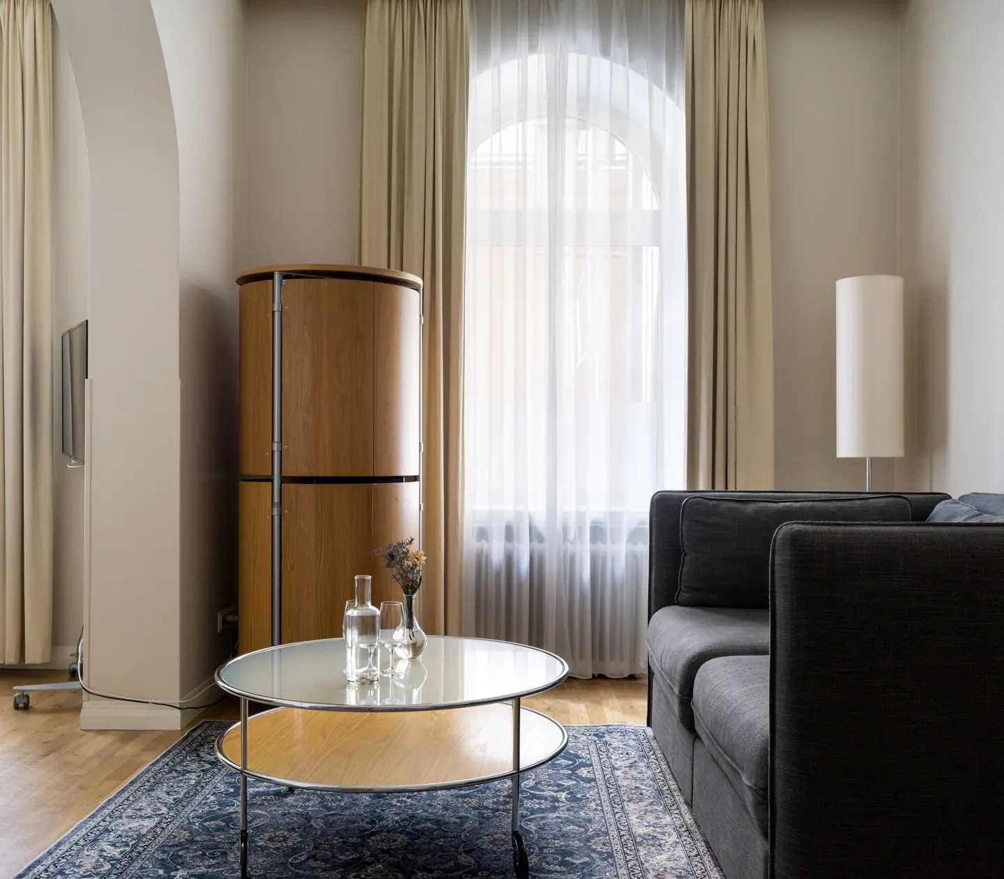 Hotellrum med kylskåp, soffa och stora fönster
