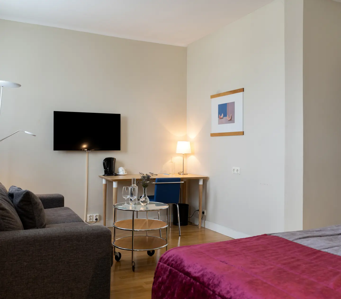 Hotellrum med soffa, skrivbord och tv