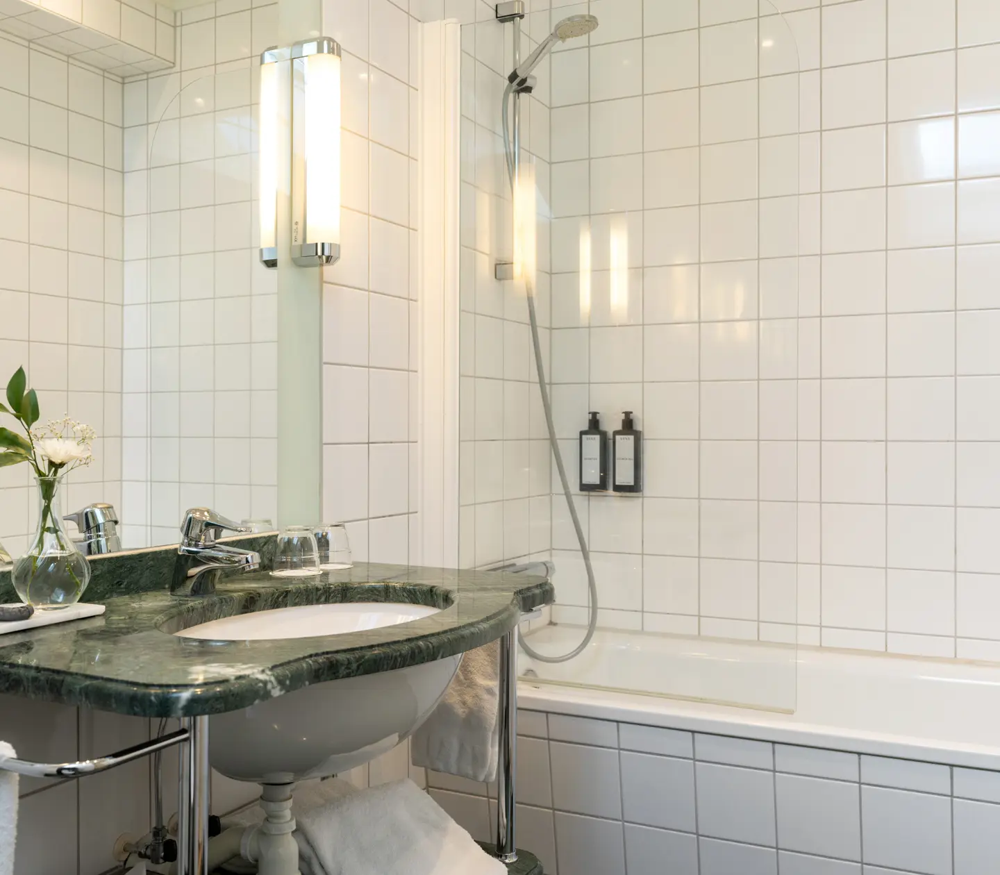 Ljust badrum med handfat, badkar och spegel