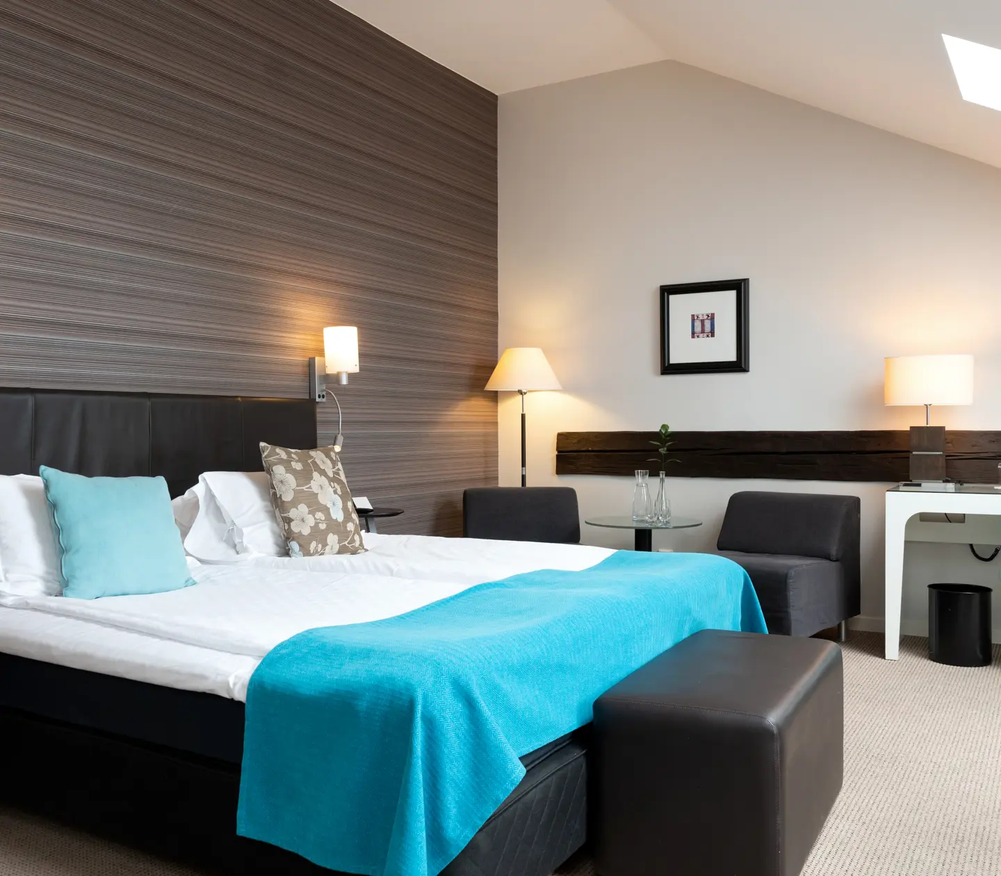 Hotellrum med snetak, dubbelsäng och skrivbord