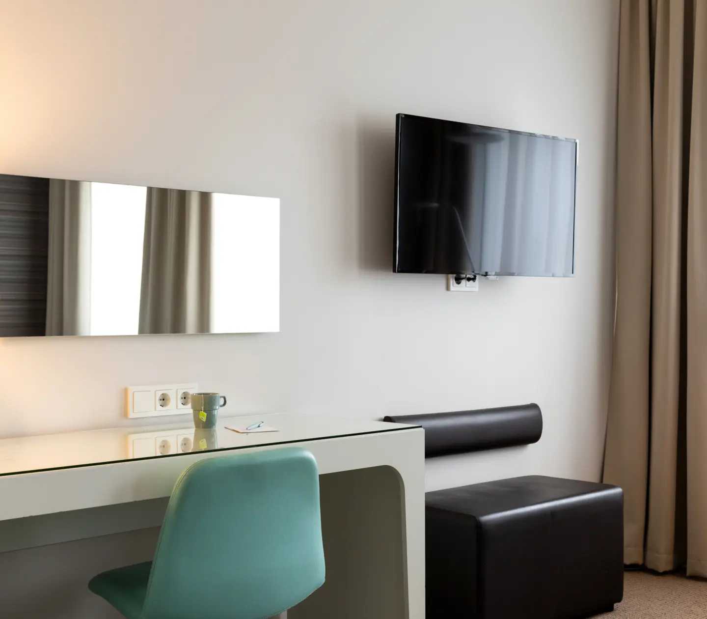 Hotellrum med skrivbord, tv och spegel
