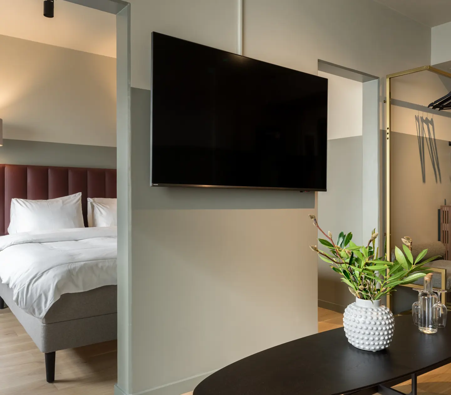 Hotellrum med dubbelsäng, tv och bukett