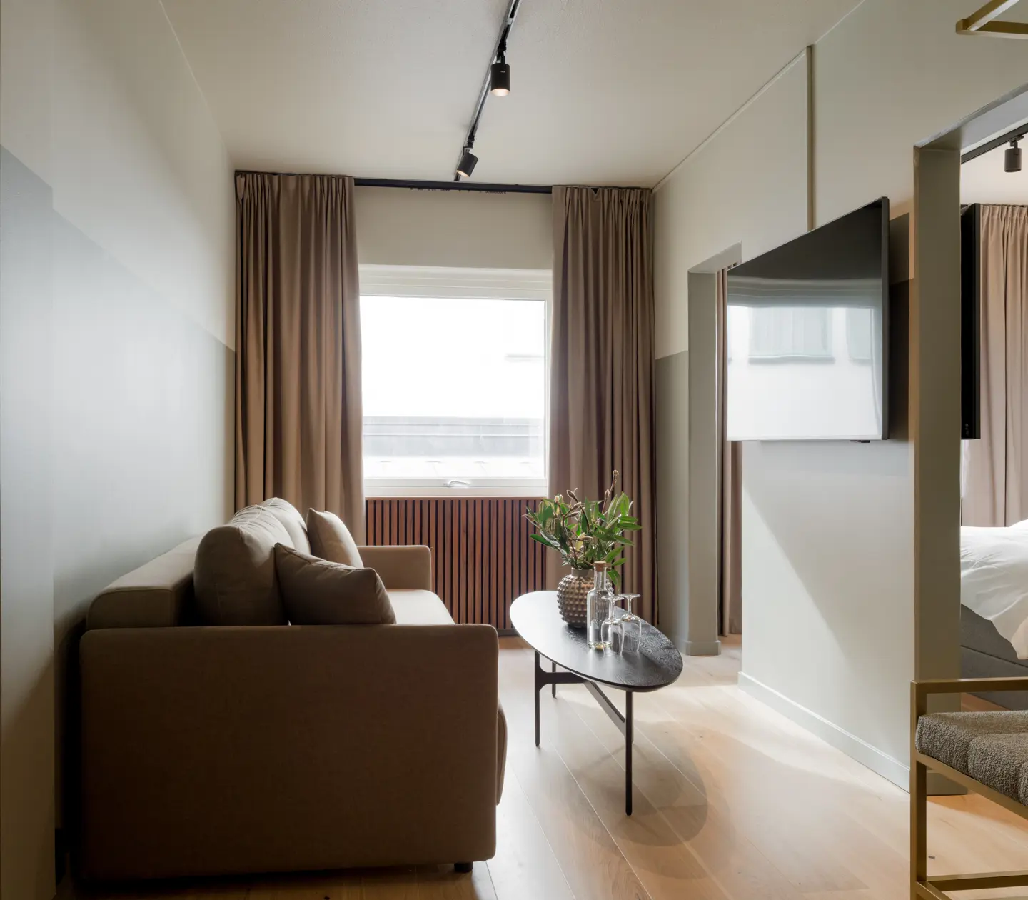 Hotellrum med soffa, tv och fönster