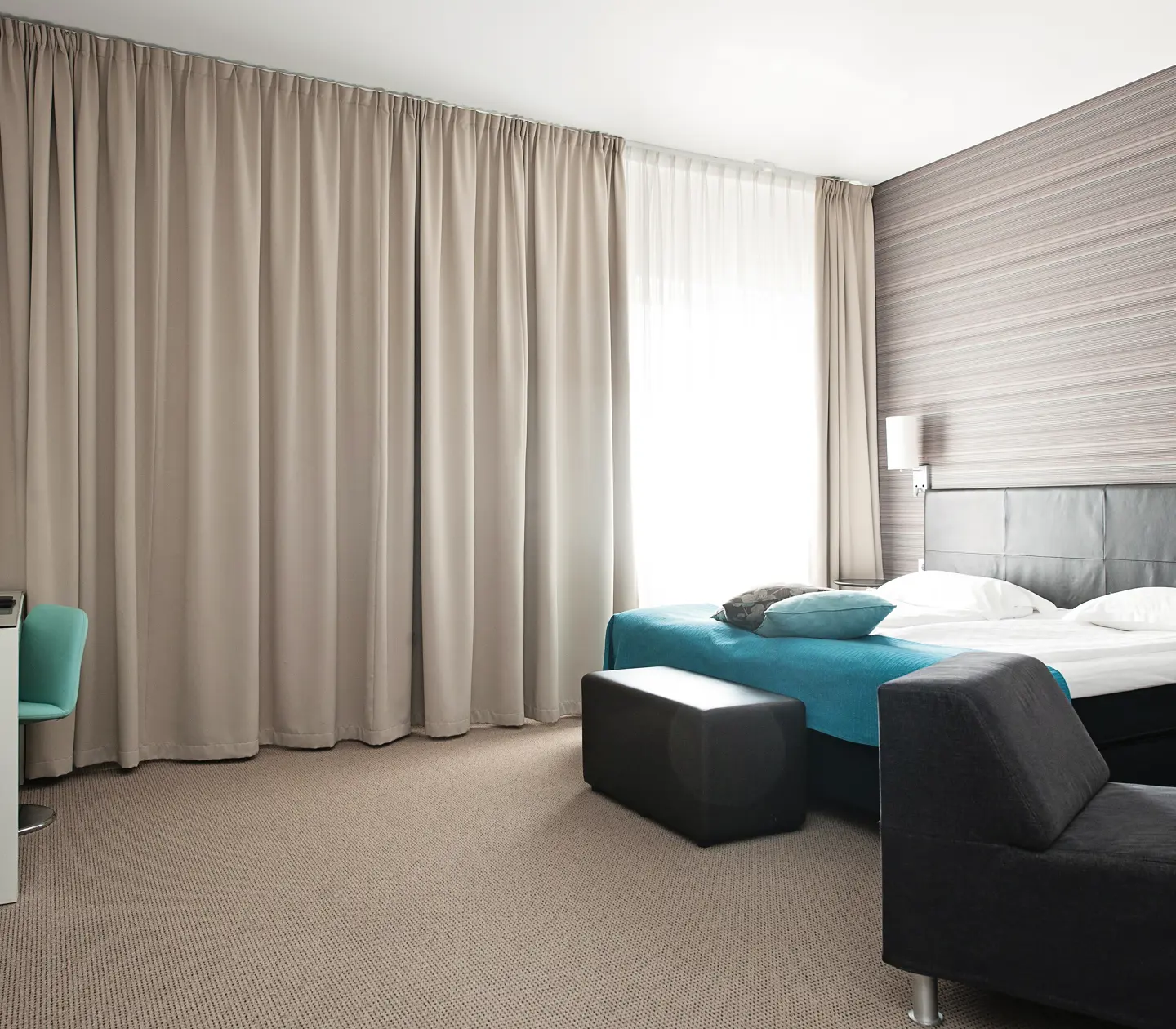 Hotellrum med matta, gardiner och dubbelsäng