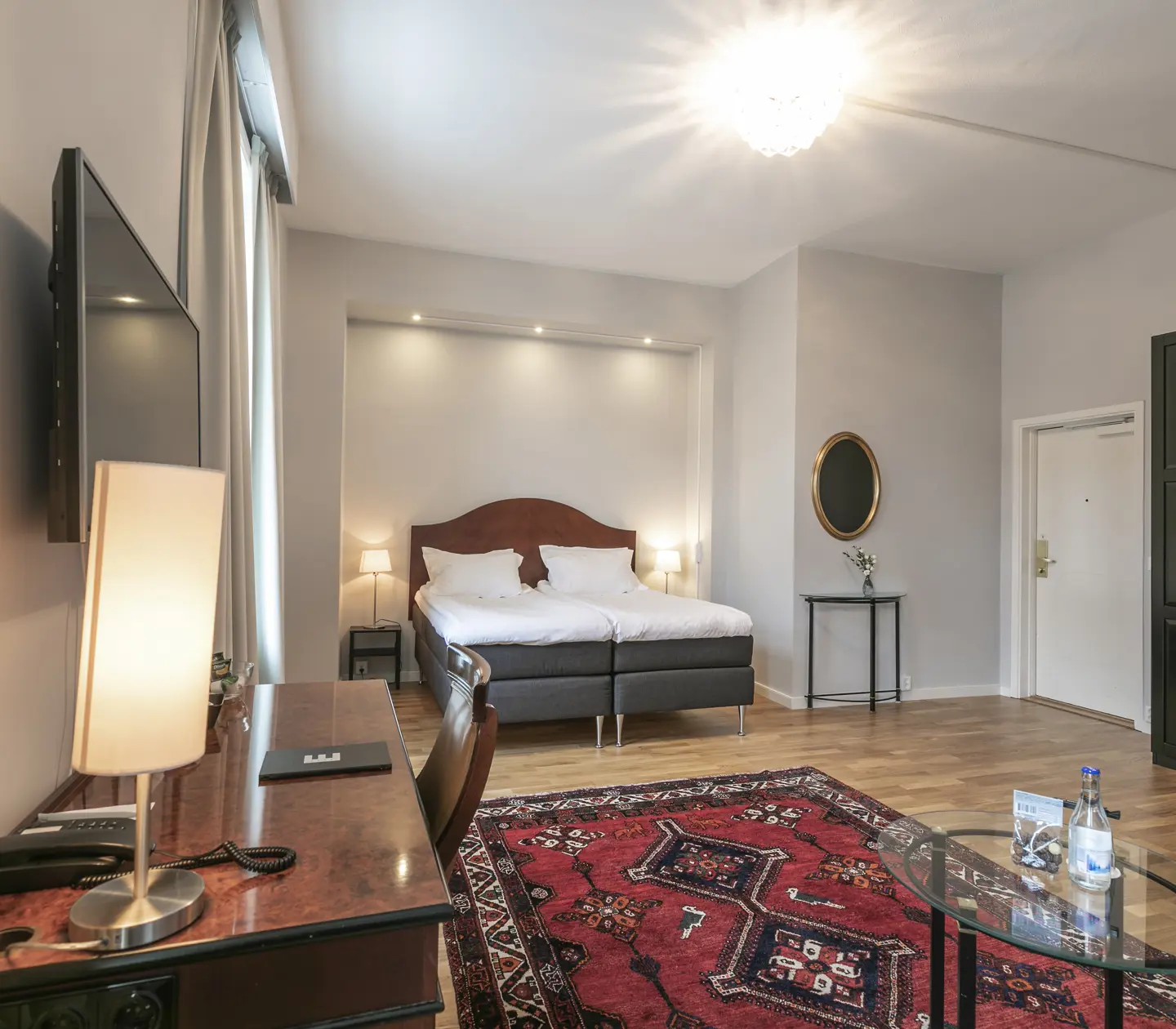 Hotellrum med dubbelsäng, skrivbord och garderob