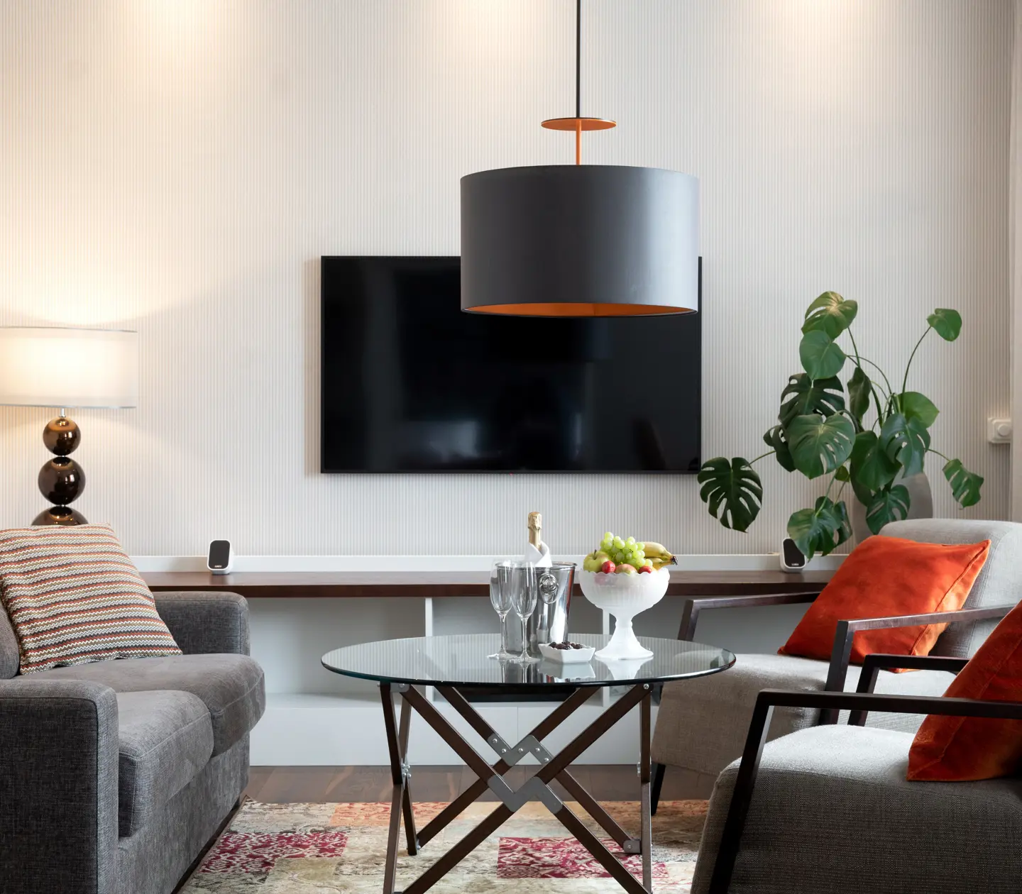 Mysigt hotellrum med soffgrupp, tv och planta