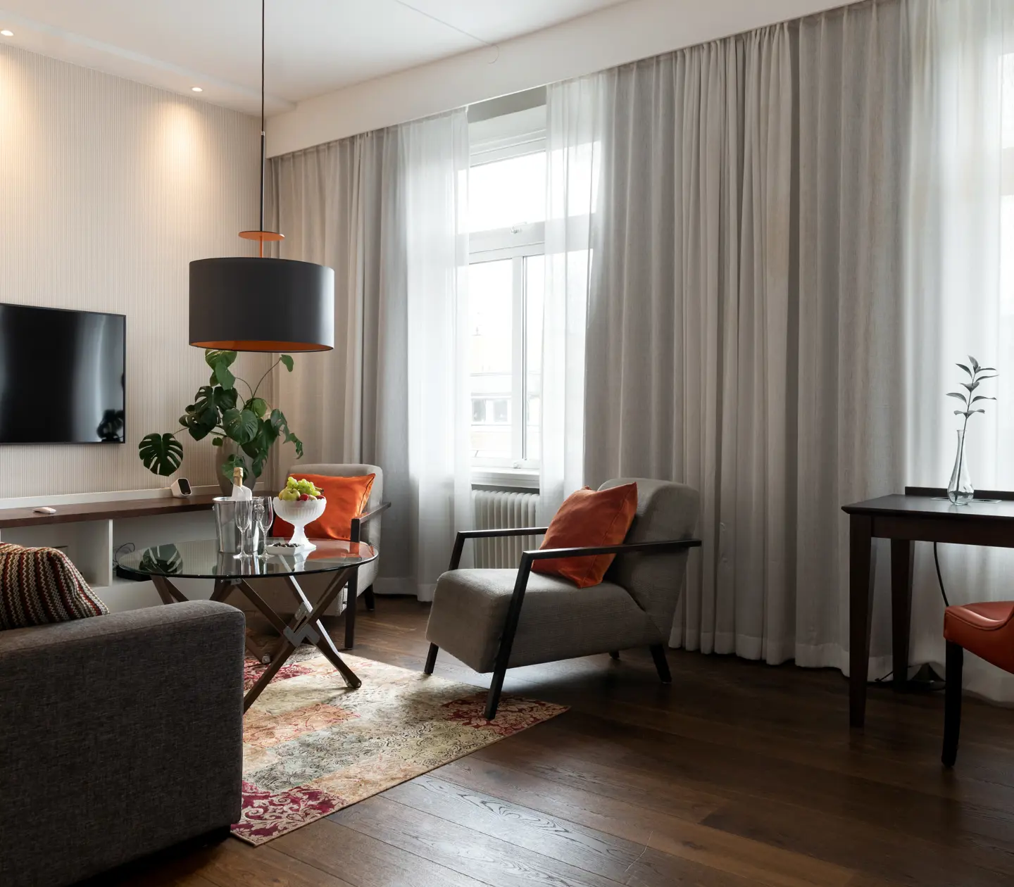 Svit med soffgrupp, tv och stora fönster