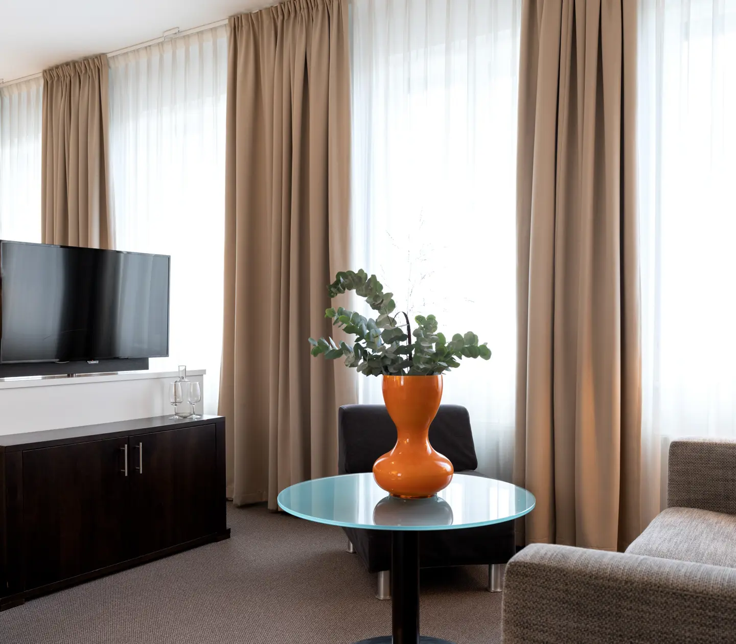 Svit med soffa, tv, säng och många fönster