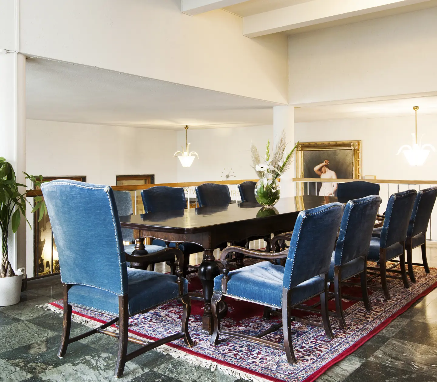 Pampigt konferensrum med högt i tak och blåa fåtöljer