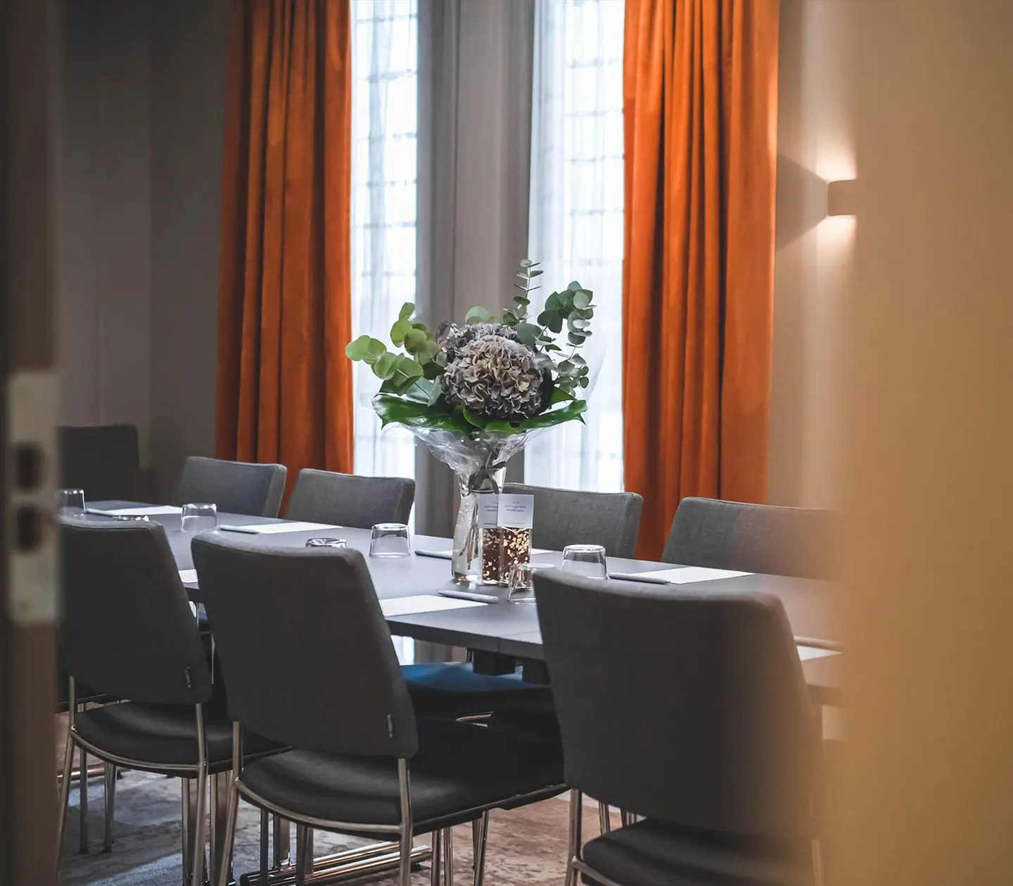 Ett konferensrum med att långt bord och blommor