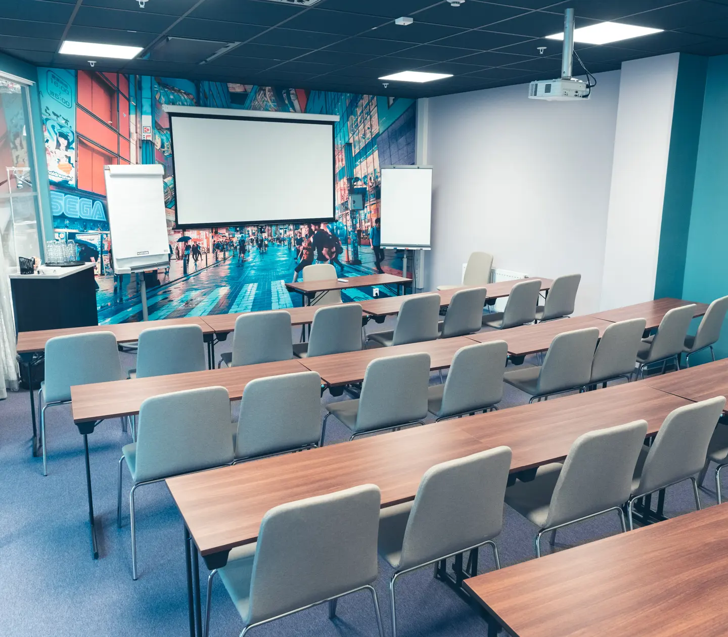 Moderna konferenslokal med projektor, vit tavla och grå stolar