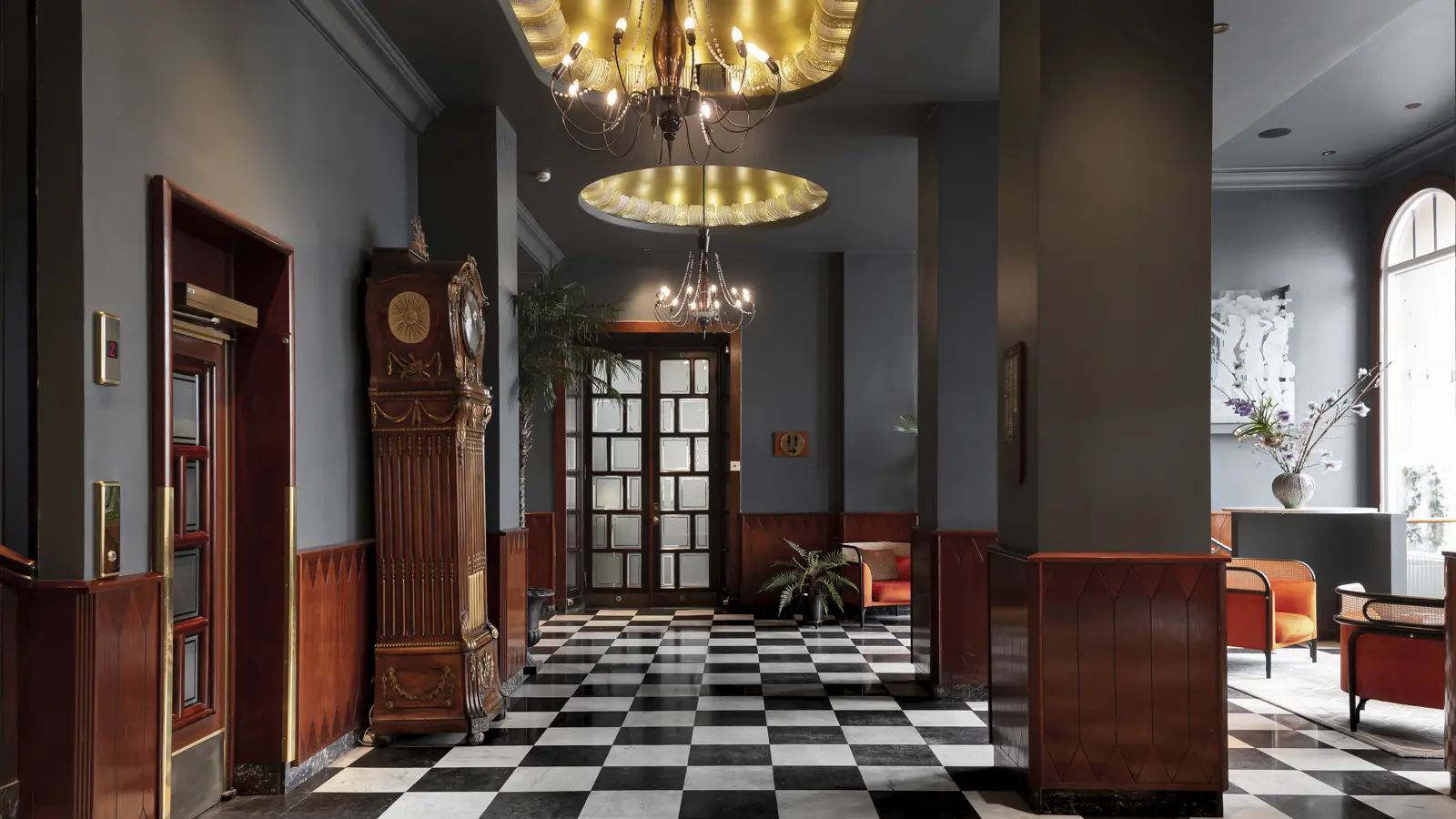 Lyxig hotellobby med schackrutigt golv, elegant golvur, och modern inredning med bekväma sittplatser och stora fönster.