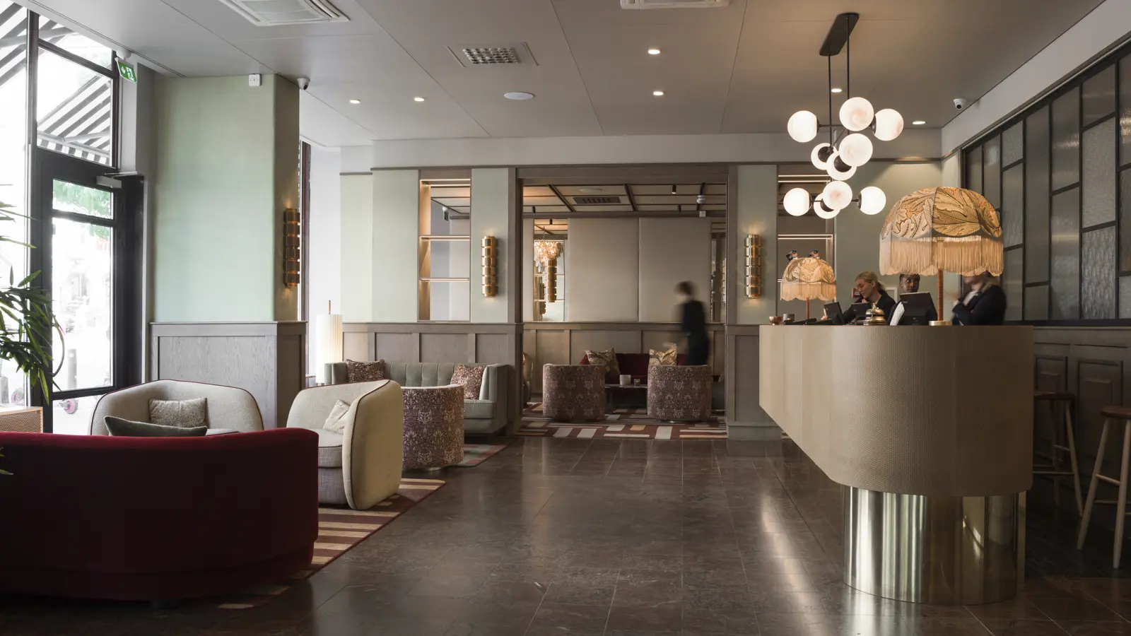 Modern hotellobby med bekväma soffor, reception och stilfull belysning.