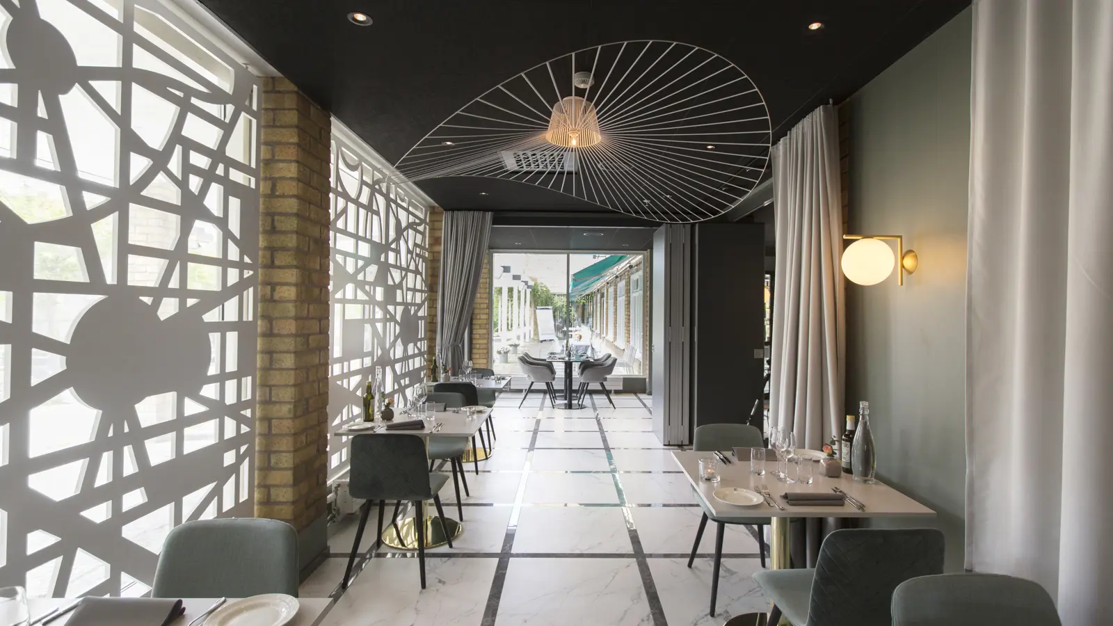 Elegant och modern restauranginteriör med minimalistisk inredning, marmorgolv och smakfulla geometriska detaljer på väggarna.
