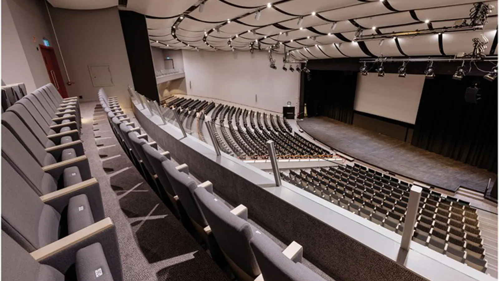 En konferenssal med en stor skärm bakom scenen