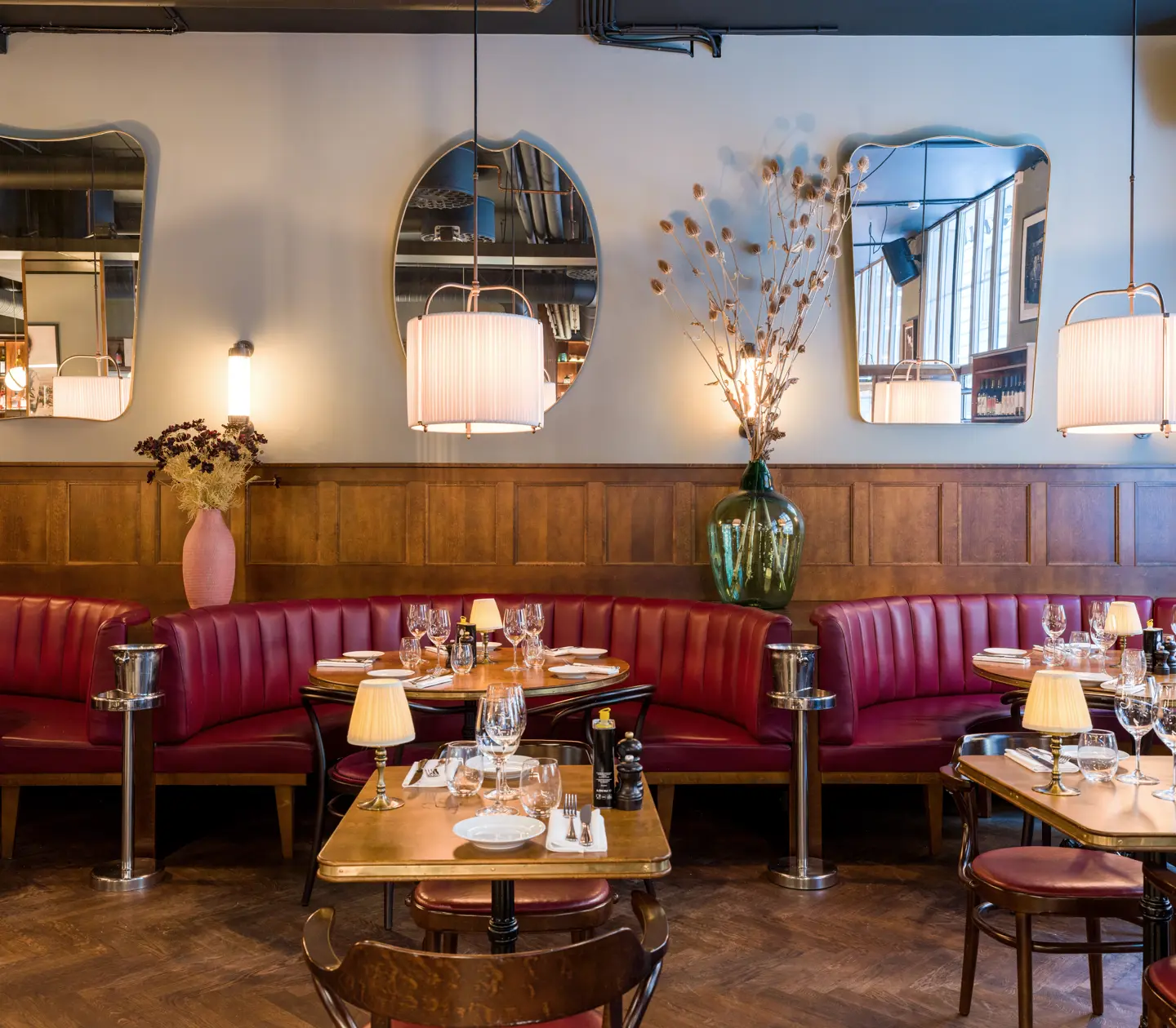 En restaurang med träinredning och bås med skinnsoffor